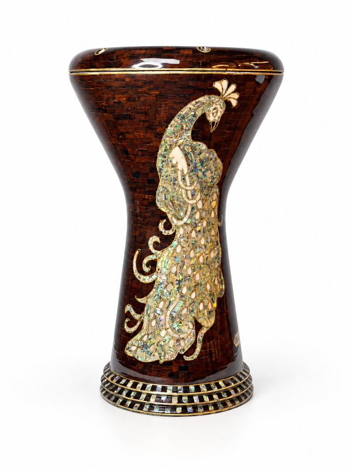 Sala Amber Peacock Sombaty darbuka standing upright, showing a pale peacock motif on a dark amber-brown mosaic background.