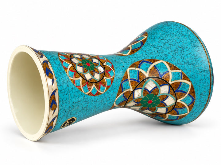 Sala Turquoise Lotus Sombaty darbuka on its side, showing the open base and turquoise-colored mosaic and layered floral medallions.
